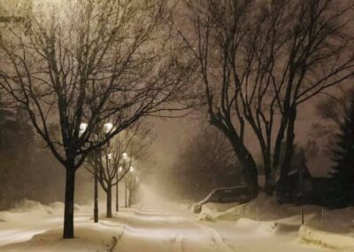 Snowy road under streetlights at night