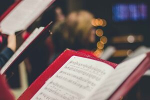 open music book with blurred background suggesting choir or concert
