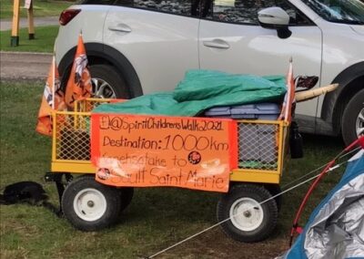 Wagon with Spirit Childrens Walk sign beside tent
